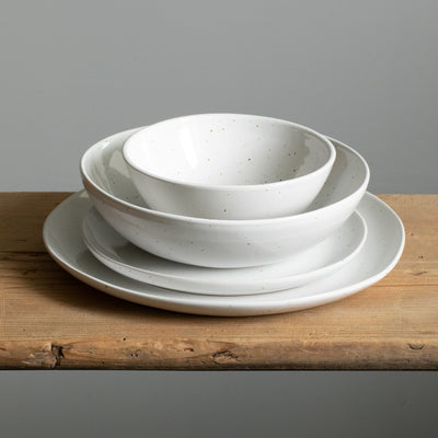 Entire tableware set stacked with a large and small plate, pasta plate and a breakfast bowl in white reactive glaze
