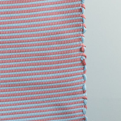 Close-up of a striped two-tone small rug with red and blue stripes
