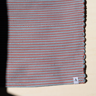 Close-up in sunlight striped small rug 60x90cm in red and blue handmade in Portugal