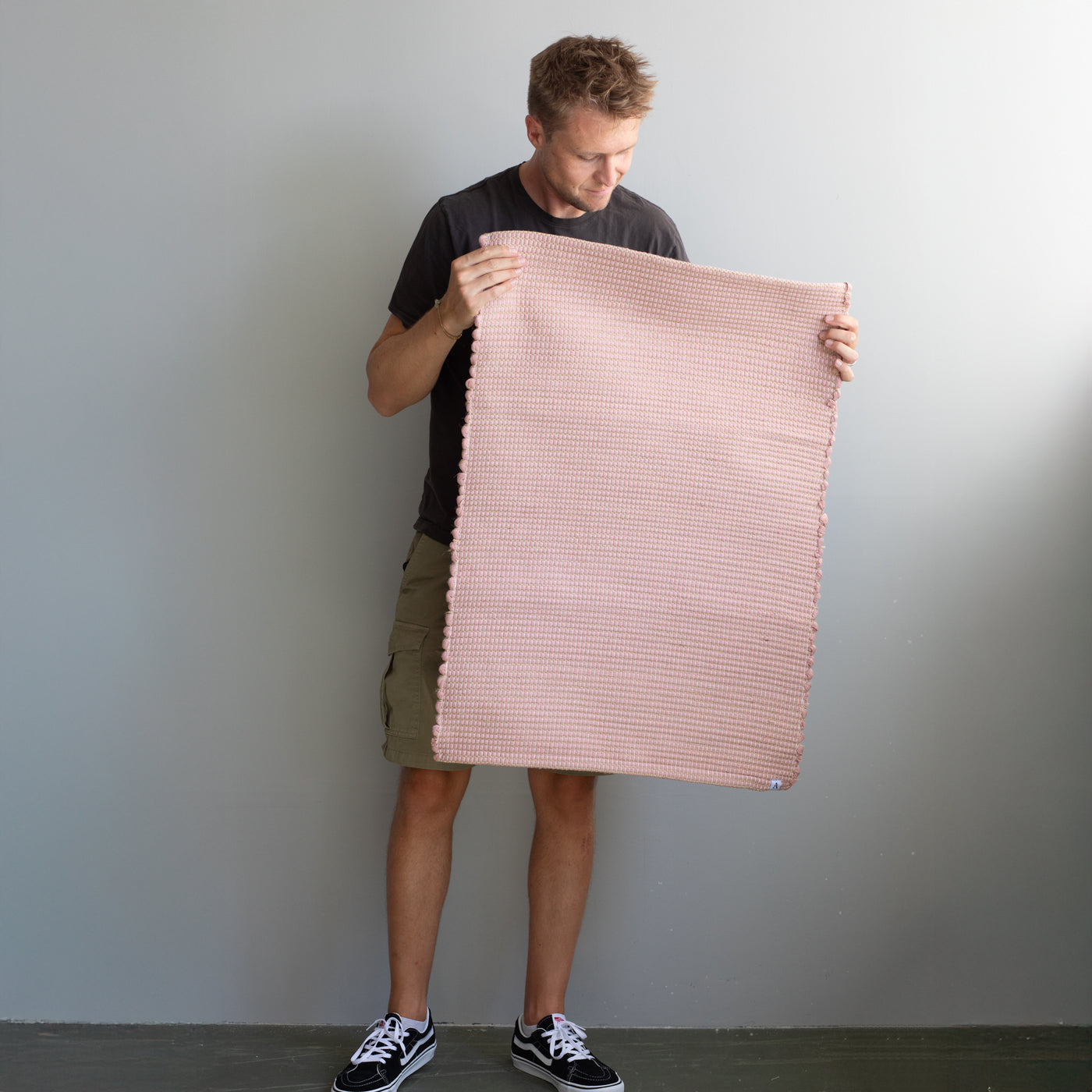 60x90cm small rug held by a person in dusky pink striped with jute hand-woven in Portugal