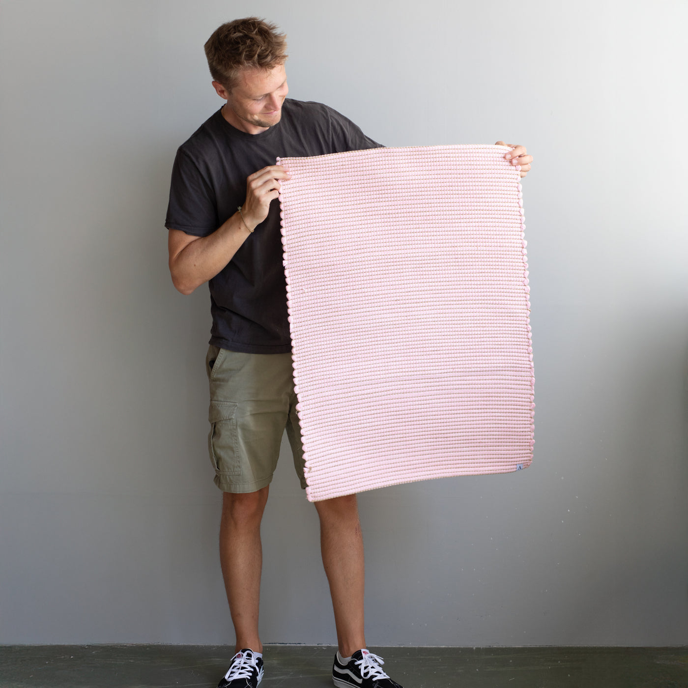 60x90cm small rug held by a person in pink striped with jute hand-woven in Portugal