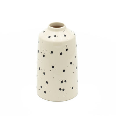 Black dotted flower vase with beige color cut out against a white background