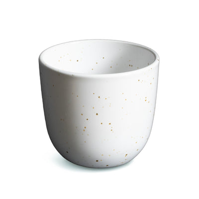 White coffee cup without handle with fine golden dots cut out against a white background