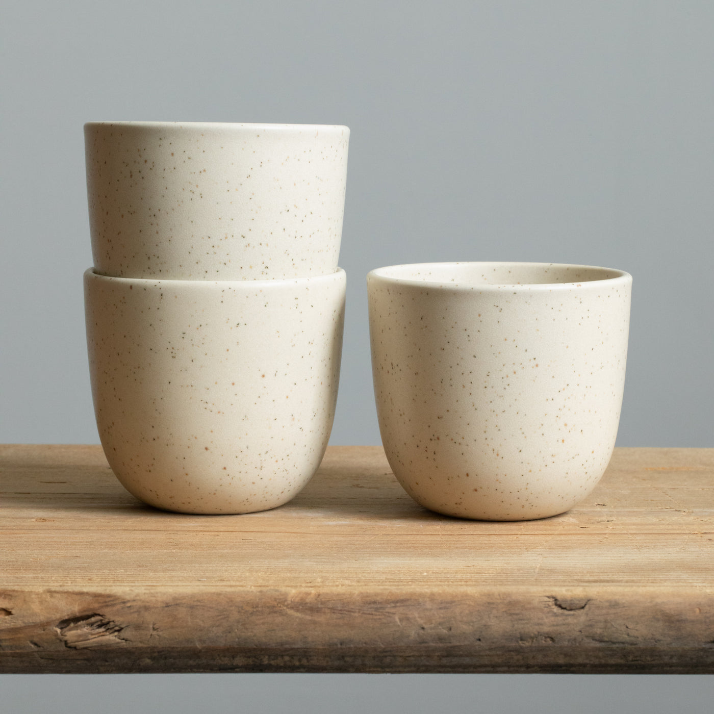 Matt beige cappuccino cups on a wooden table