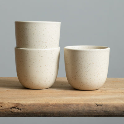 Matt beige cappuccino cups on a wooden table