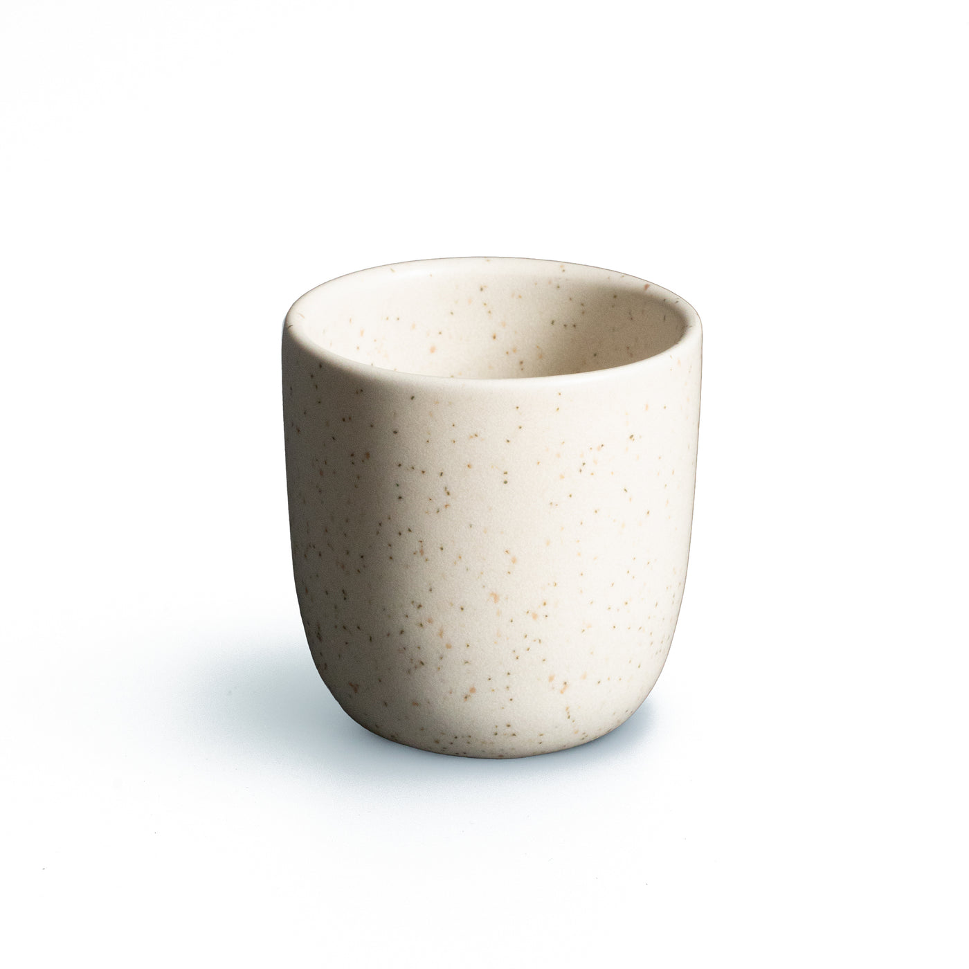 Matt beige espresso mug without handle cropped against a white background