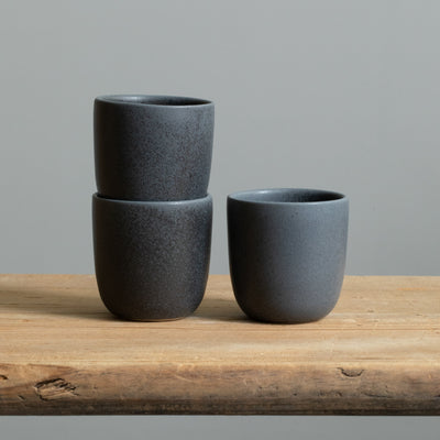 Three stacked matt black espresso cups in a simple design