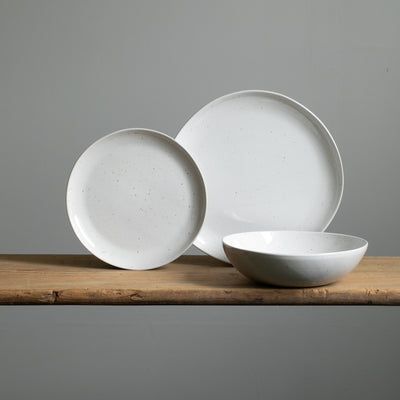 You can see a large main course plate and a small starter plate placed in front of a deep pasta plate with white glaze