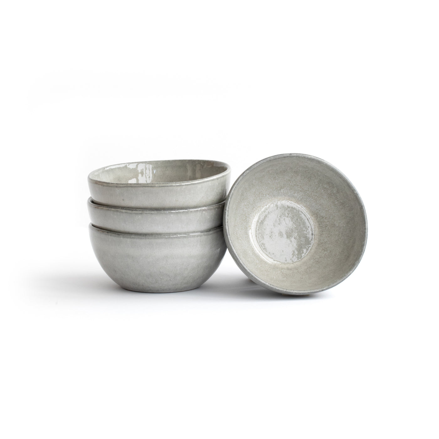 Three stacked and one leaning light gray snack bowl cropped against a white background