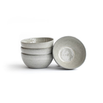 Three stacked and one leaning light gray snack bowl cropped against a white background