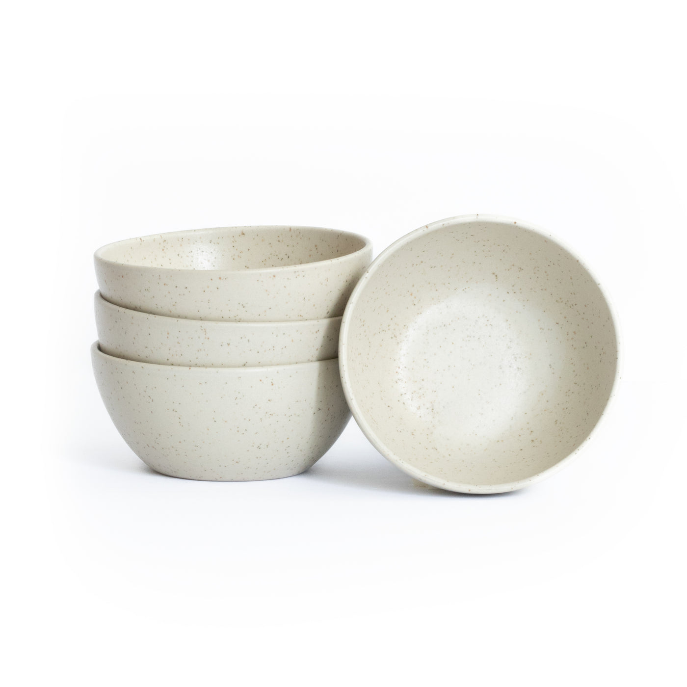 Three stacked and one placed snack bowl in matt beige cropped against a white background