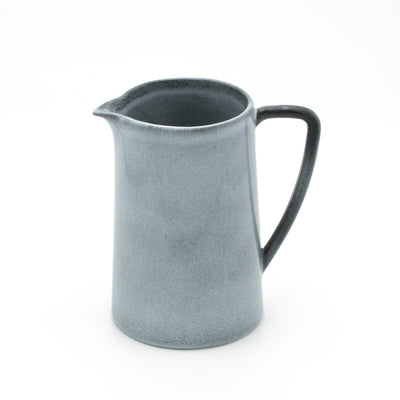 Jug with fine large handle in blue mottled color cut out against a white background