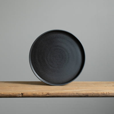 Large plate with angled rim made of stoneware in matt black glaze