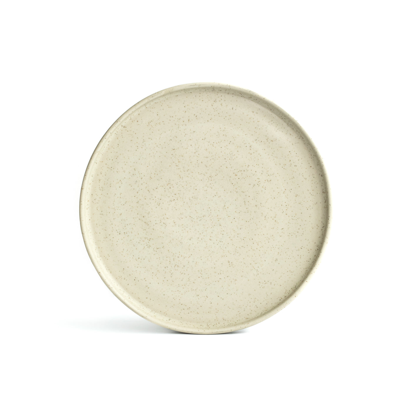 A large plate in matt speckled beige set up with angled edge against a white background, cropped