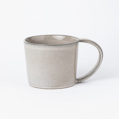 Large teacup with handle in light gray and a large handle in front view against a white background