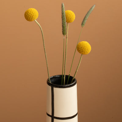 Close-up of the opening of a thin black checkered vase that looks like a fireplace
