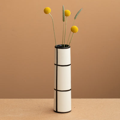 Thin vase in white color black checkered and yellow and green flowers