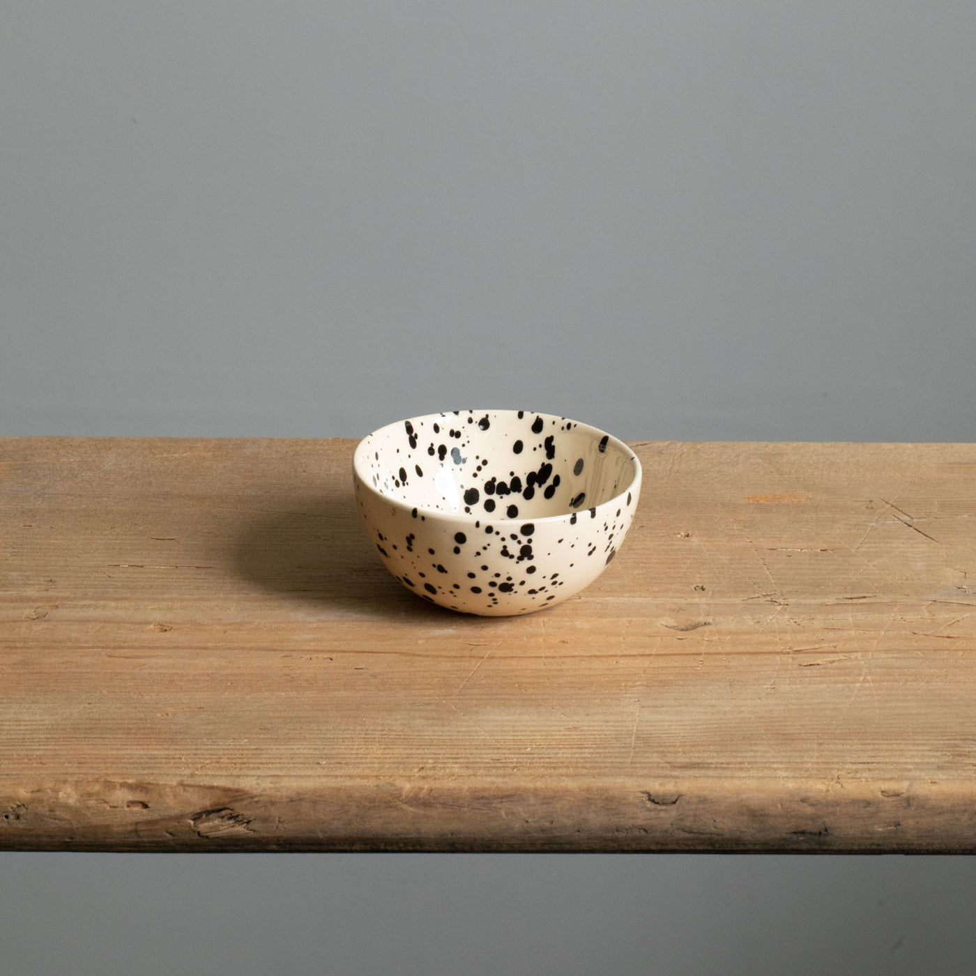 Small snack bowl with cream-colored glaze and black dots perfect for nuts and dips