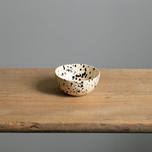 Small snack bowl with cream-colored glaze and black dots perfect for nuts and dips