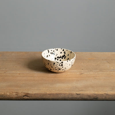 Small snack bowl with cream-colored glaze and black dots perfect for nuts and dips