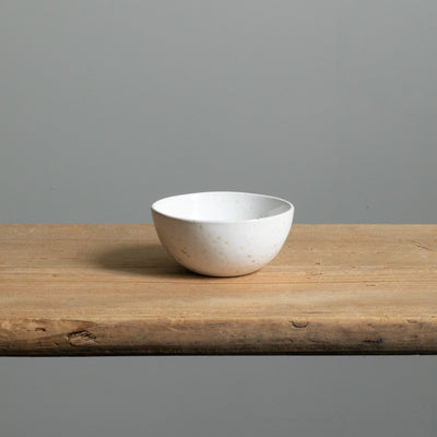 Front view of the small white snack bowl on a wooden board