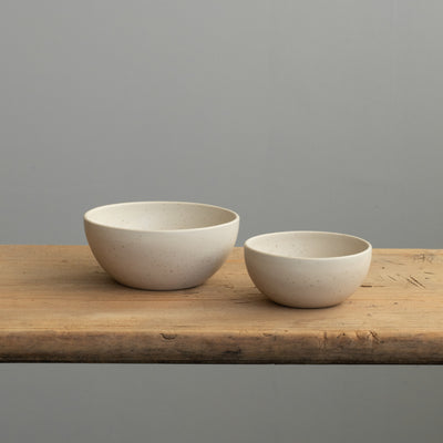 A small and large matt beige snack bowl next to each other to see the difference in size.