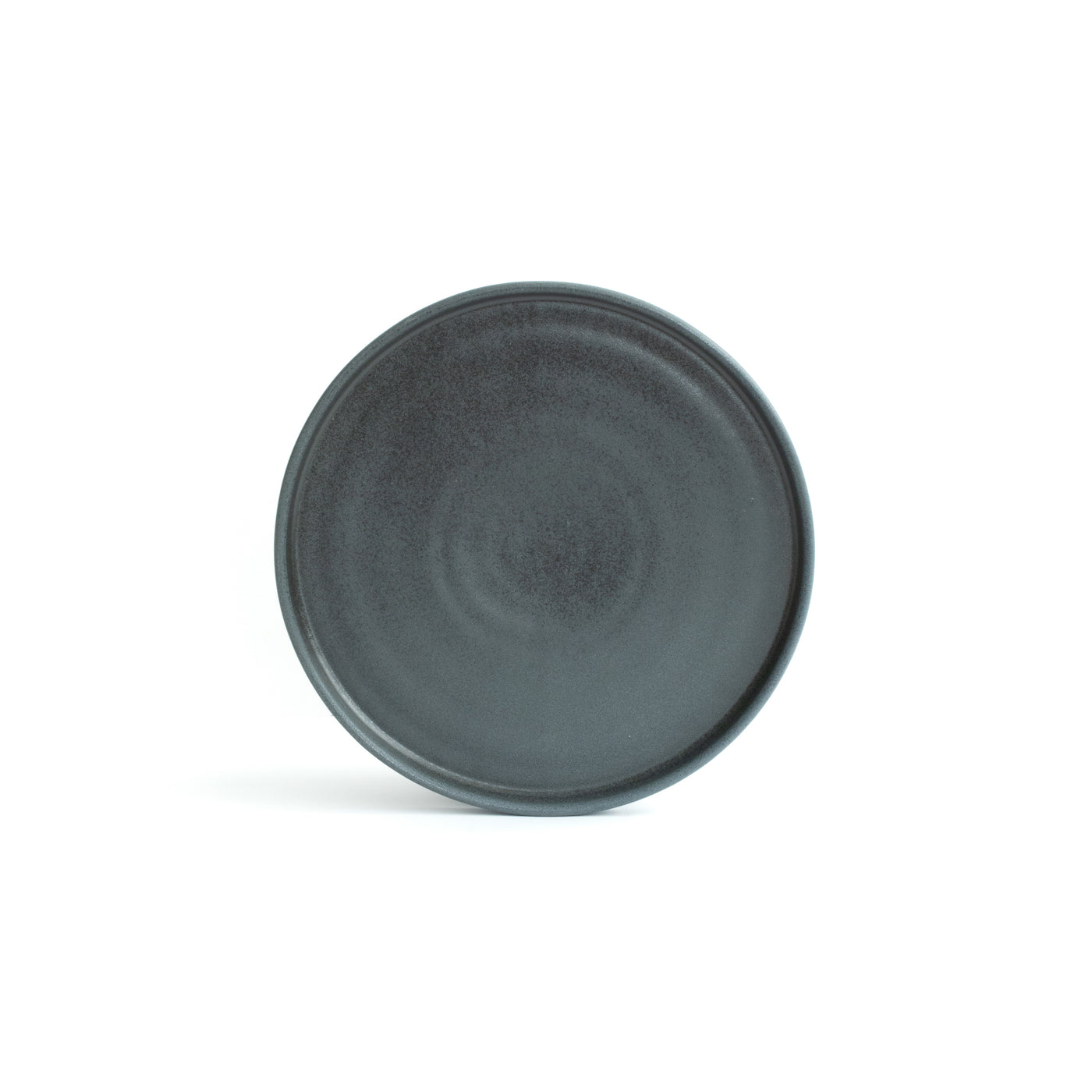Small matt black plate with angled rim, positioned and cropped