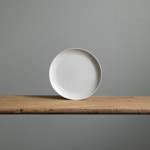 Small stoneware breakfast plate with white glaze and golden brown spots