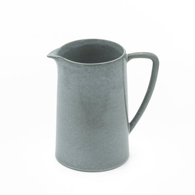 Jug in dark gray with large handle cropped in front of white