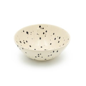 Muesli bowl in beige color with black dots against a white background