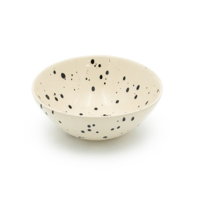 Muesli bowl in beige color with black dots against a white background
