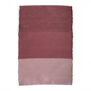 Carpet divided into three color blocks from bordeaux to pink against a white background