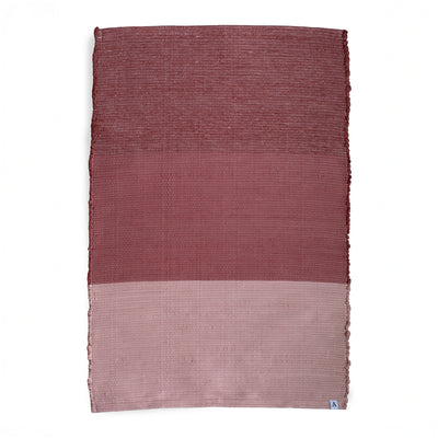 Carpet divided into three color blocks from bordeaux to pink against a white background