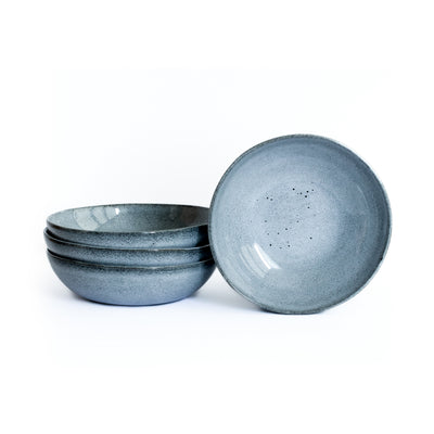 Main course pasta plate in blue mottled glaze cropped against a white background