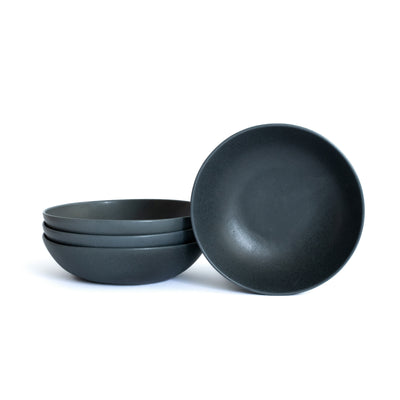 Matte black pasta plate cropped against a white background