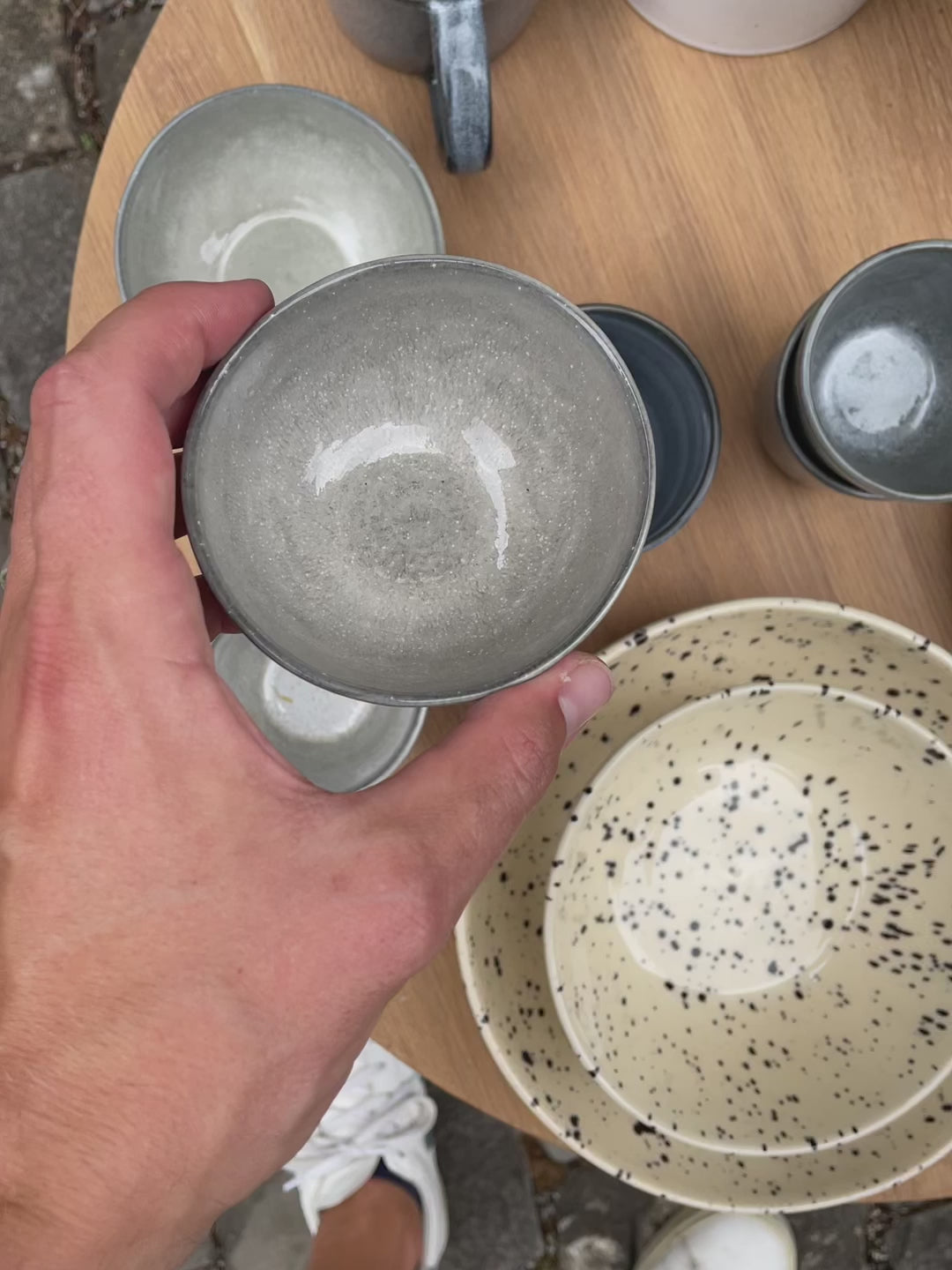 The small light gray snack bowl is shown from all sides. The bowl has an organic shape and a glossy Midnight Grey glaze.