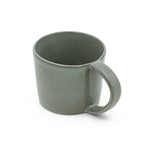The large dark gray stoneware tea cup with handle is set against a white background 
