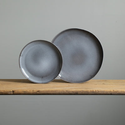 Upright large plate and small plate in blue mottled glaze made of robust stoneware