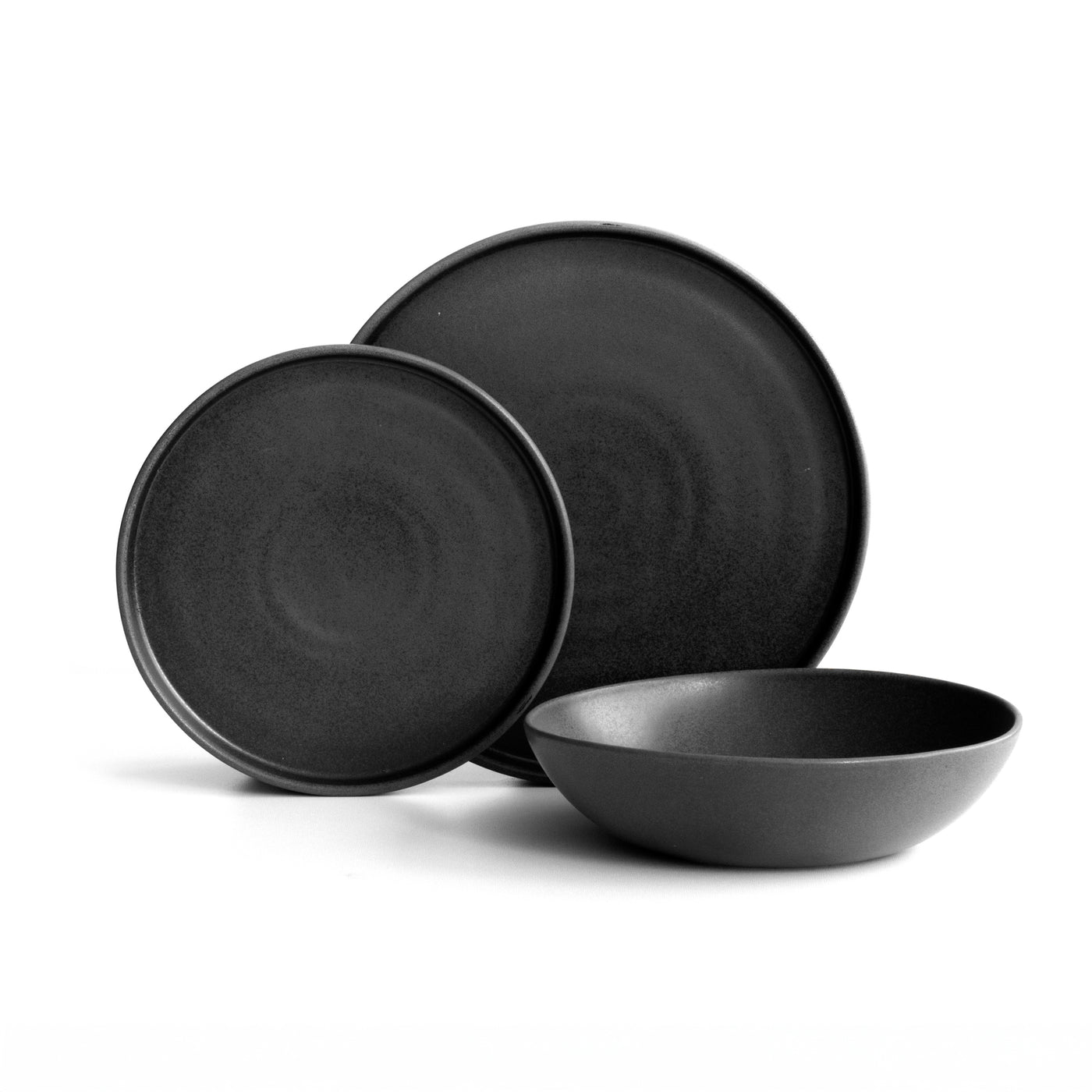 Small and large plate with straight edge and a deep pasta plate in matt black cropped against a white background