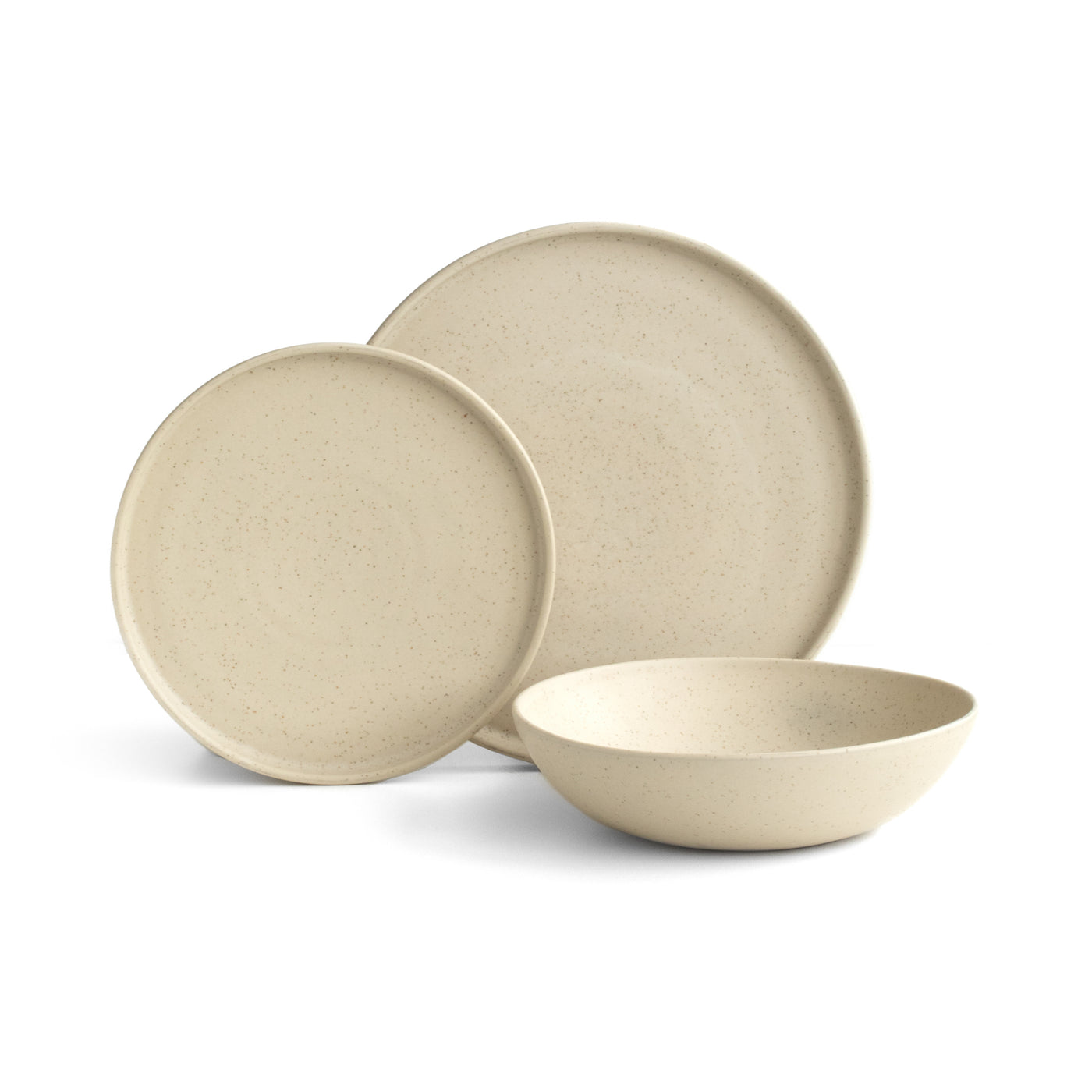 A large and small plate with a straight edge set up in front of a pasta plate in the color Speckled Beige against a white background