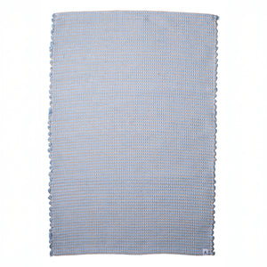 Small jute-striped rug in light blue made from wool remnants hand-woven in Portugal against a white background