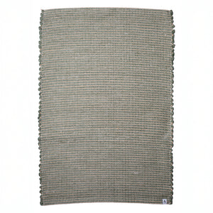 Small jute-striped rug in green made from wool remnants hand-woven in Portugal against a white background