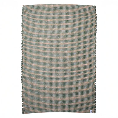 Small jute-striped rug in green made from wool remnants hand-woven in Portugal against a white background