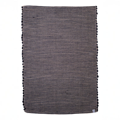 Small jute striped rug in black made from wool remnants hand-woven in Portugal in front of a white background