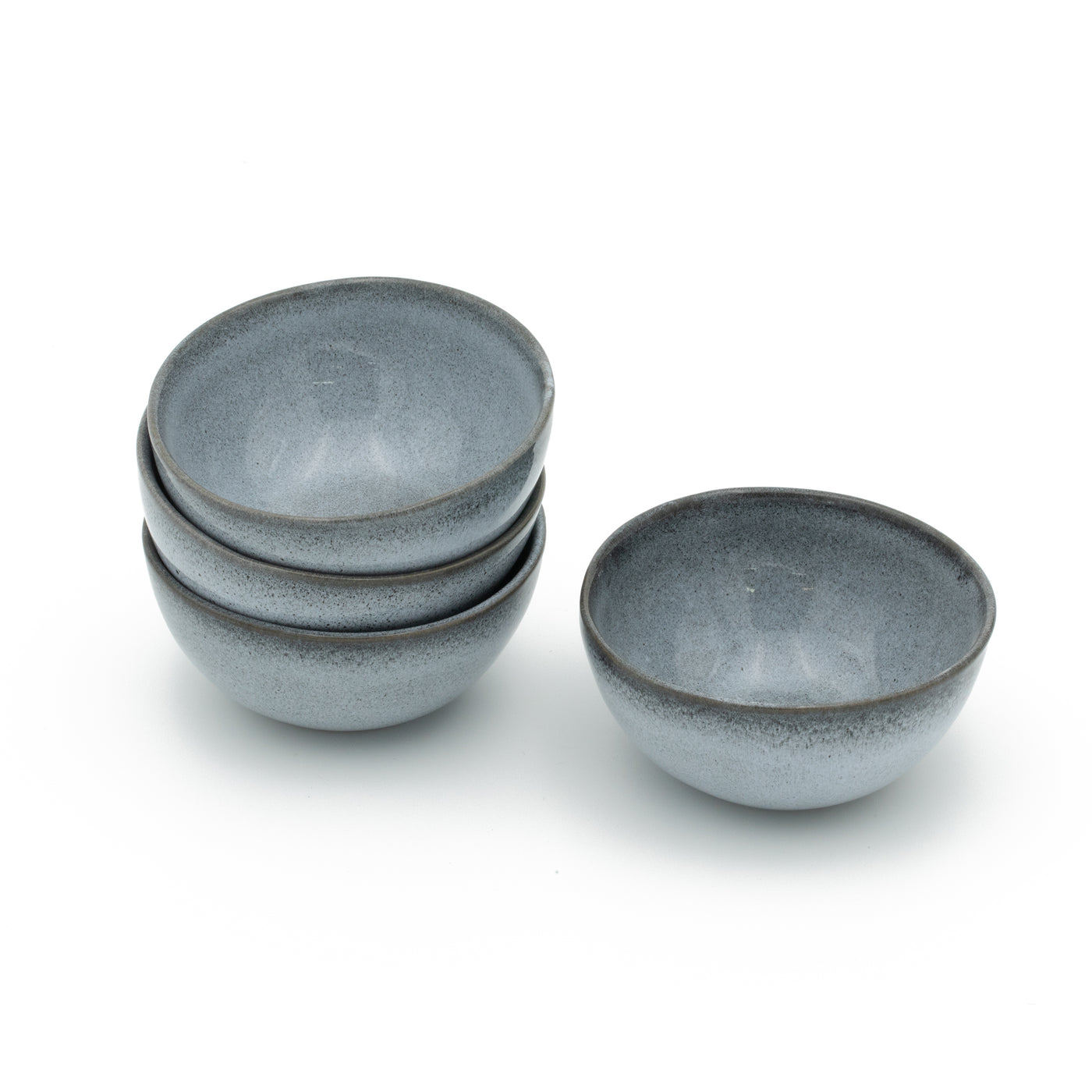 Four small blue snack bowls stacked on top of each other with a white background